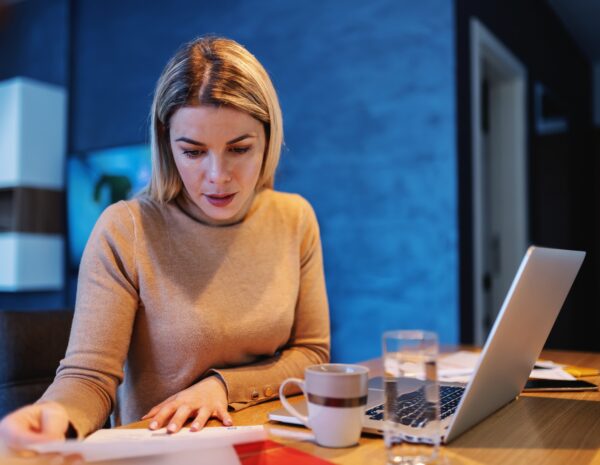 A woman sits at a computer.