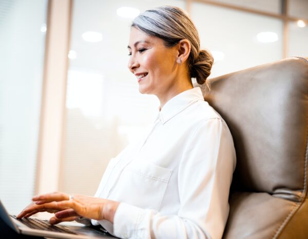 An older woman sits at a computer.