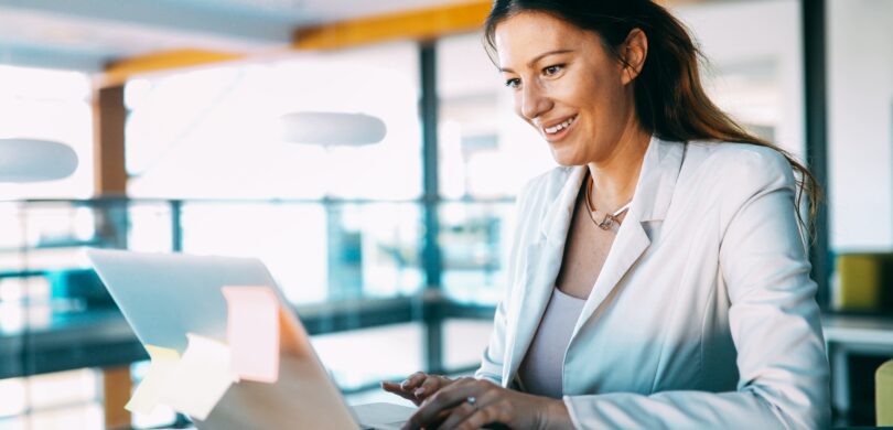 A woman sits at a computer.