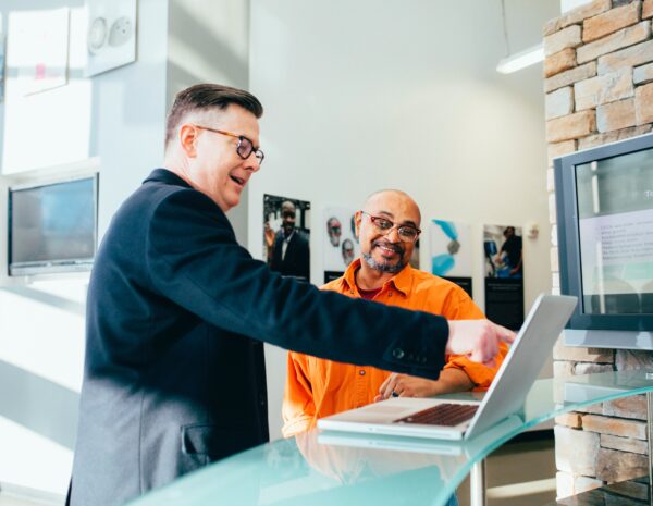 Two men looking at a computer.