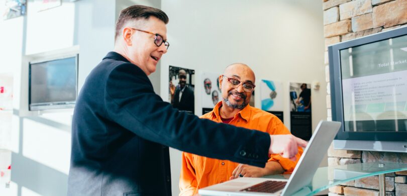 Two men looking at a computer.